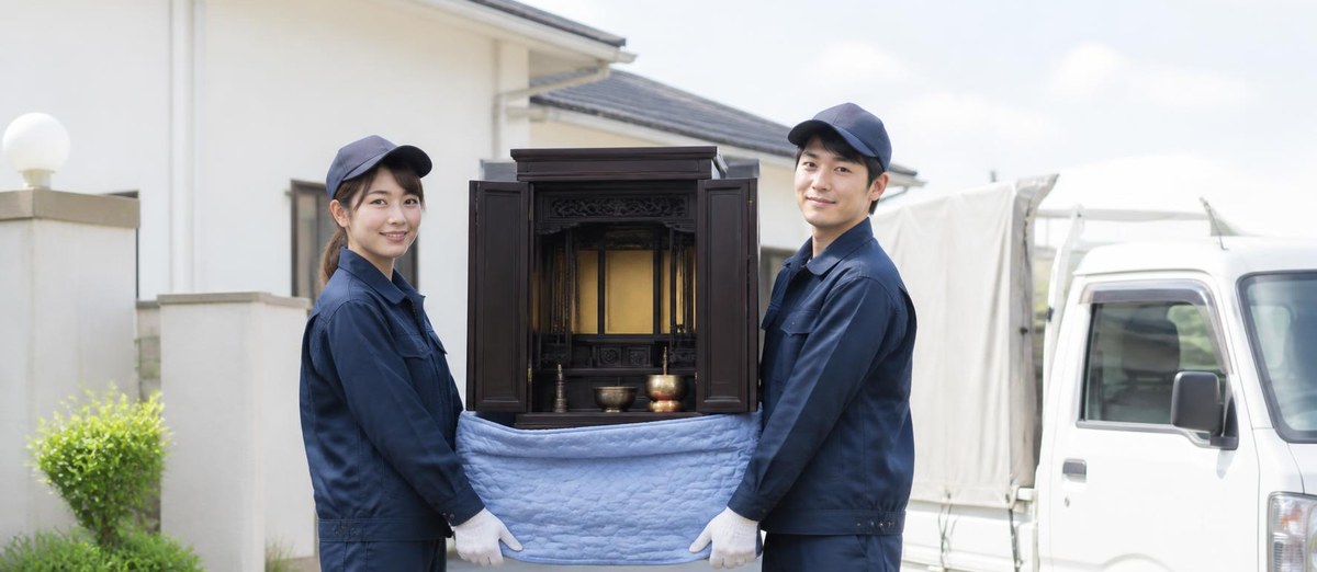 お仏壇を運び出して軽トラックに積むスタッフ