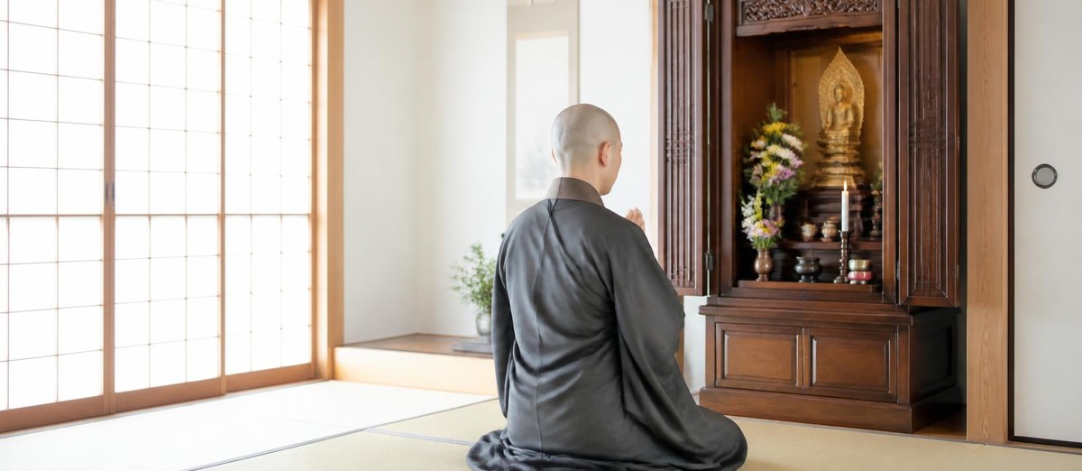 お仏壇の前で合掌する僧侶